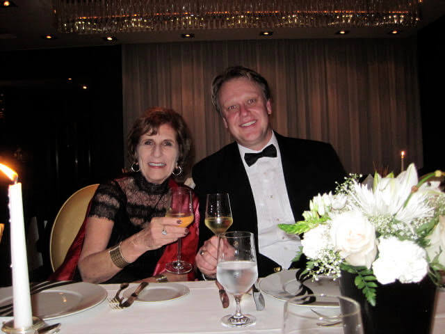 couple in formal wear toasting