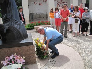 an American man lays a wreath at the base of a memorial as a way of honoring the fallen