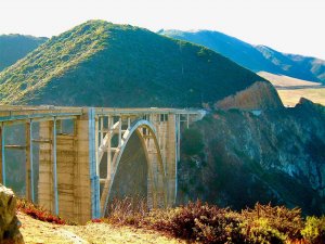 cross the Bixby Creek Bridge on your California roadtrip. Image shows Bixby Creek Bridge in the distance.