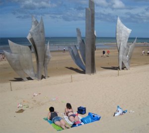 Two people sunbathing on Omaha beach.