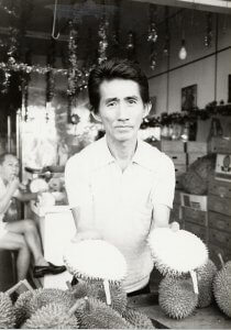 Man holding two pieces of Durian also called stink fruit in Singapore