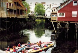 Small boat sailing through river towards red building