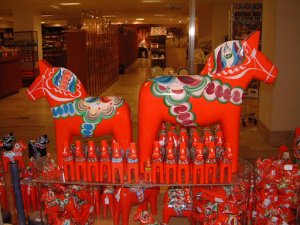 two vibrant orange horse statues with blue, green, white, and pink saddle designs facing opposite direction