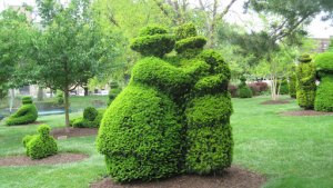 topiary couple wearing hats hugging