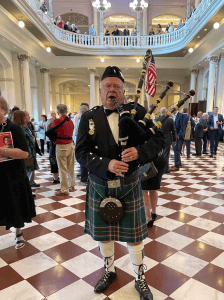 THE PIPER WITH HIS BAGPIPE IN MUSIC HALL FOYER